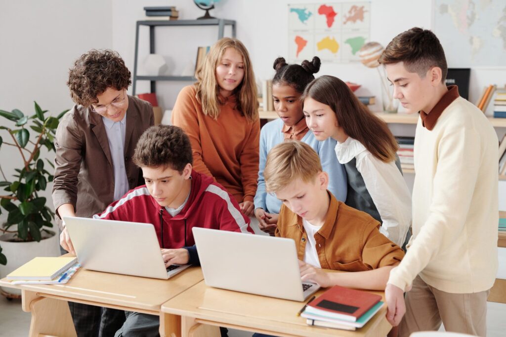 Students learning together on laptops, guided by AI and extended reality tools