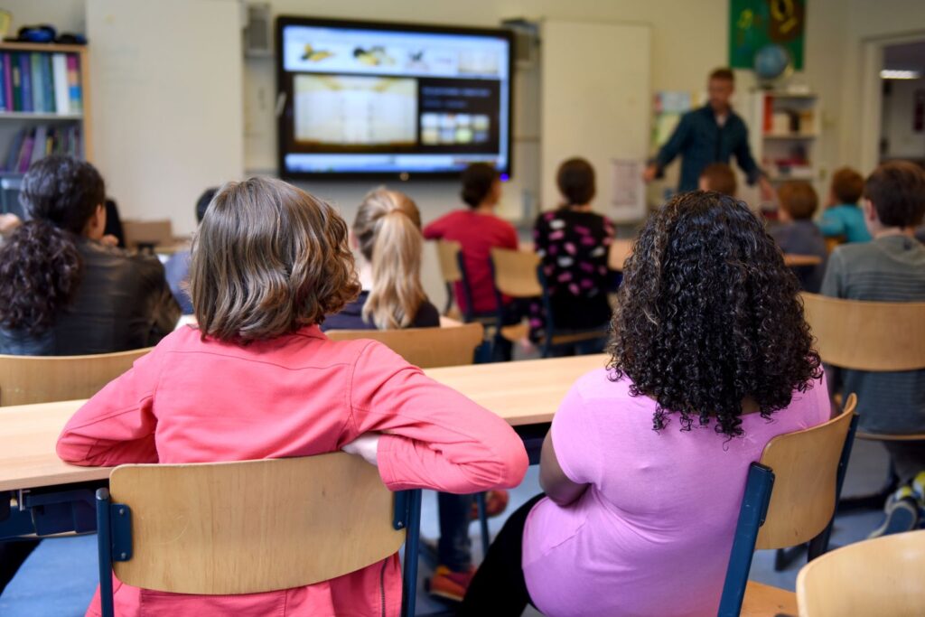 Students in a busy classroom ready for an augmented reality in the classroom activity