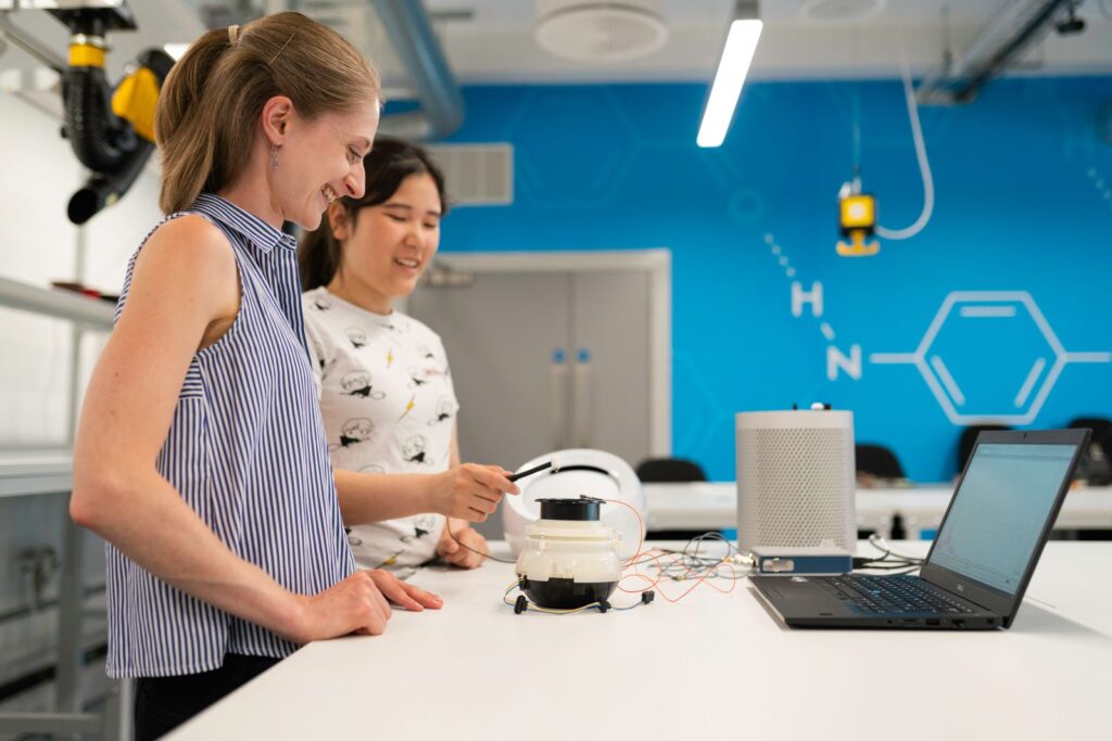 Engineers in a modern lab testing equipment linked to a digital twin for engineering education