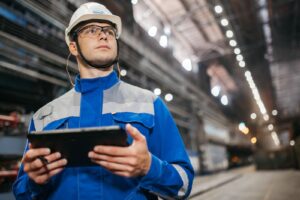 Worker holding a tablet in a factory, a real world model for the digital twin in education