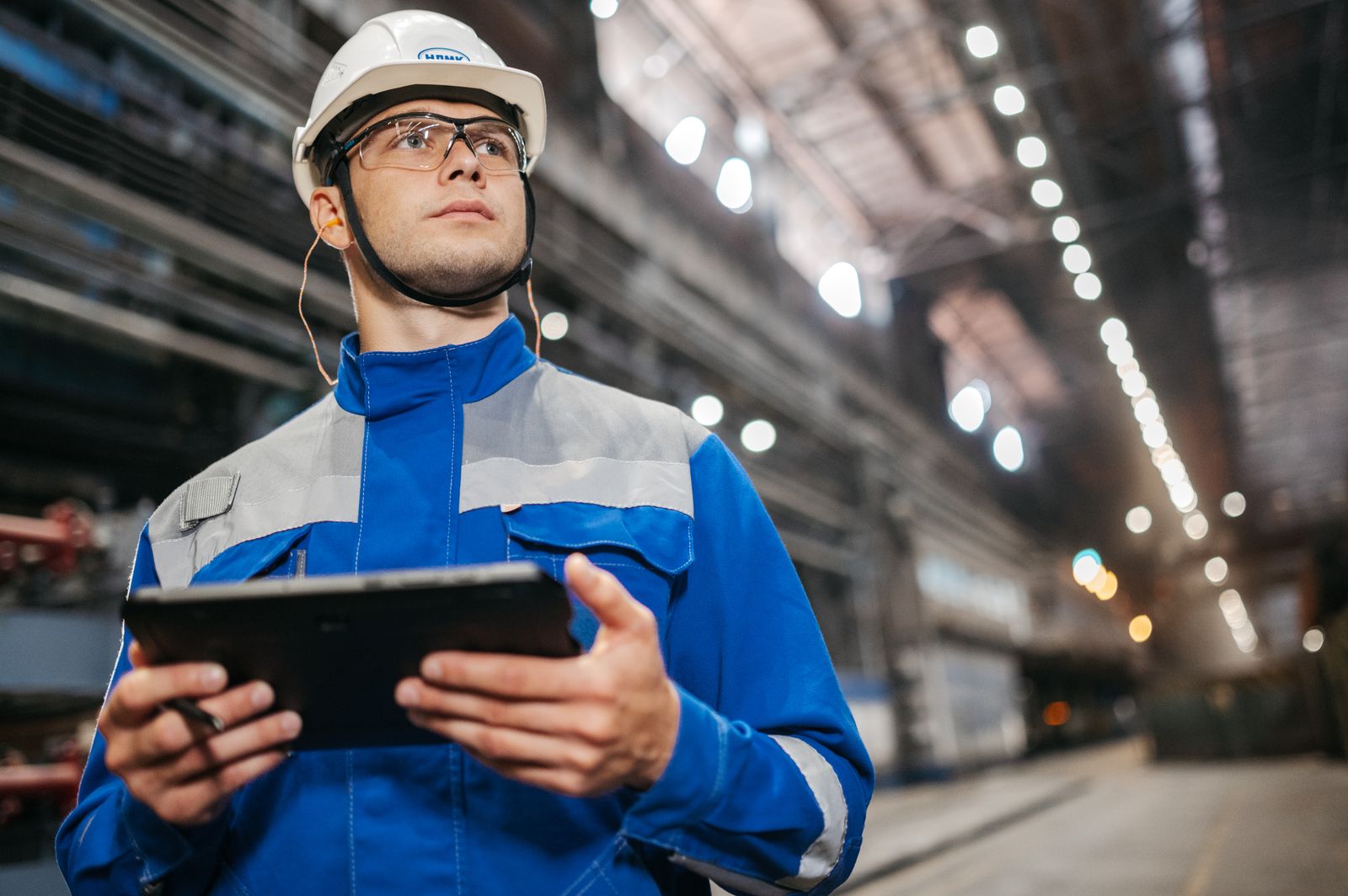 Worker holding a tablet in a factory, a real world model for the digital twin in education