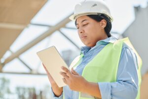 Digital twin technology in education shown by an engineer checking a live model on a tablet