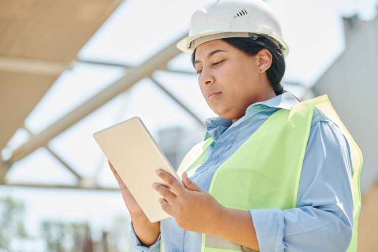 Digital twin technology in education shown by an engineer checking a live model on a tablet