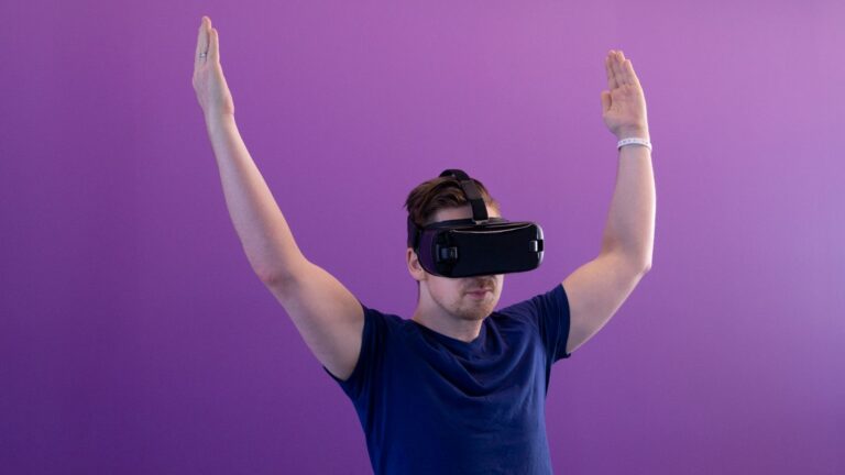 A student with arms raised inside a VR headset, exploring the metaverse in education