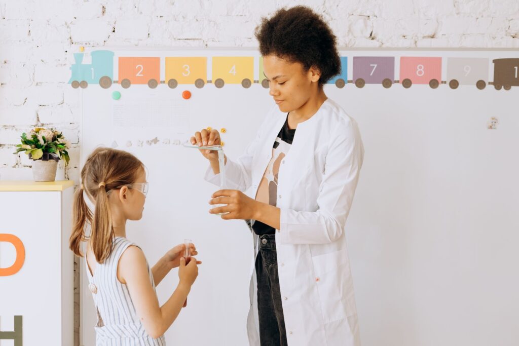 A teacher and student doing a science experiment together, a core NEP 2020 experiential learning activity